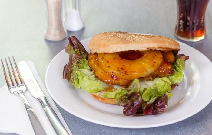 Frutti Chicken Burger: Hähnchenbrustfilet (paniert), Salat, Tomate, Ananas