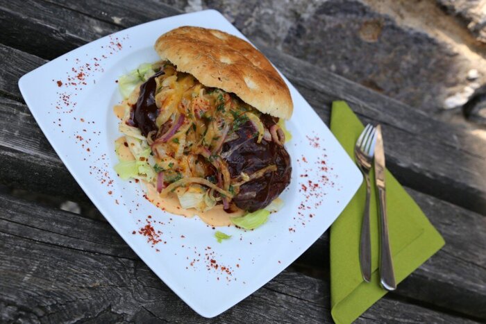 W.A.P RIB - Hamburger mit saftigem Rindfleisch, BBQ-Sauce, gedämpften Cheddar-Zwiebeln, Gurke und Salat