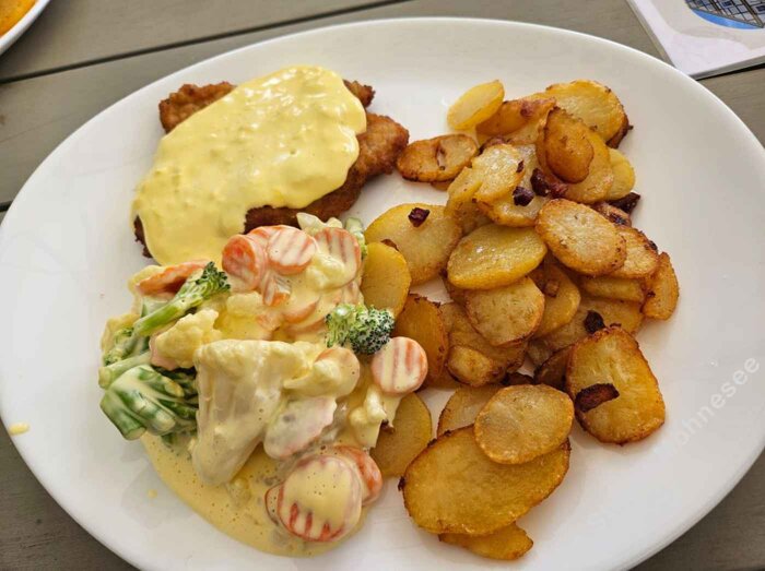 Schnitzel Wiener Art mit Kaisergemüse, Sauce Hollandaise und knusprigen Bratkartoffeln.