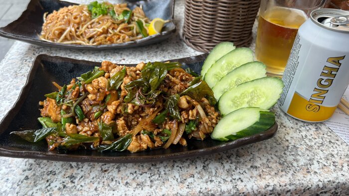 Gehacktes Hühnerfleisch, gebraten in Chili- und Knoblauchsoße mit Thai-Basilikum, Zwiebeln, Lauchzwiebeln und Gurke.
