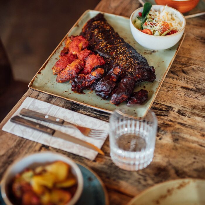 Zarte BBQ-Ribs mit hausgemachten Beilagen – ein Klassiker der TEXAS Steaklounge.