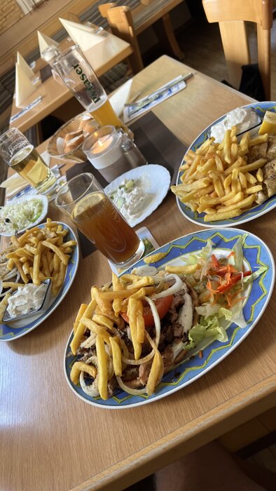 Gyros Pita (vorne), Athen Platte (links) und gegrillte Calamari (rechts)