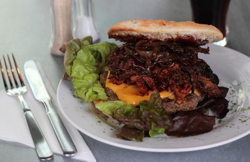 Turf & Pulled Pork Burger: Rindfleisch, Pulled-Pork, Salat, Käse, Bacon, Balsamicozwiebeln.